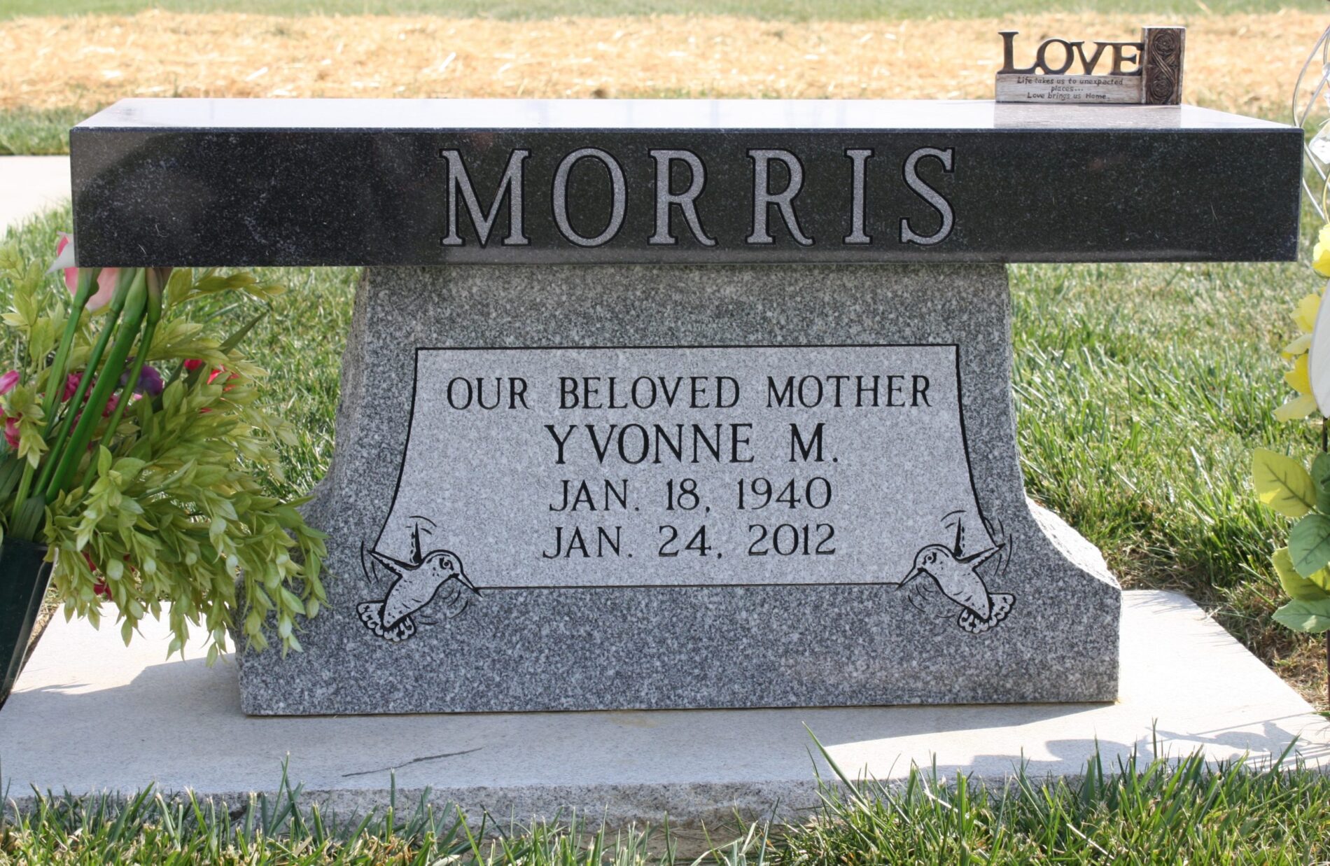Granite grave marker for Yvonne M. Morris, with dates Jan 18, 1940 – Jan 24, 2012, and decorative doves.