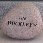 Granite garden memorial stone with engraved floral design and decorative carved details.