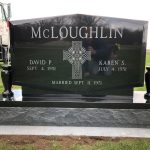Polished granite cemetery headstone with engraved lettering and decorative memorial design.