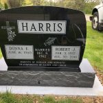 Polished granite upright cemetery headstone monument with engraved lettering and decorative design.