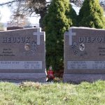 Polished granite double headstone monument with decorative engraving for a family cemetery memorial.